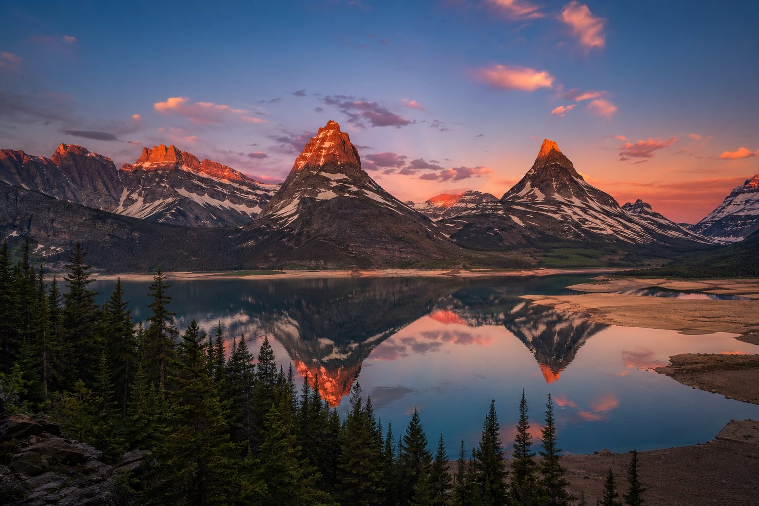 Modern photograph of Glacier National Park alpine peaks reflected at sunset representing Nation Movers' Montana service area